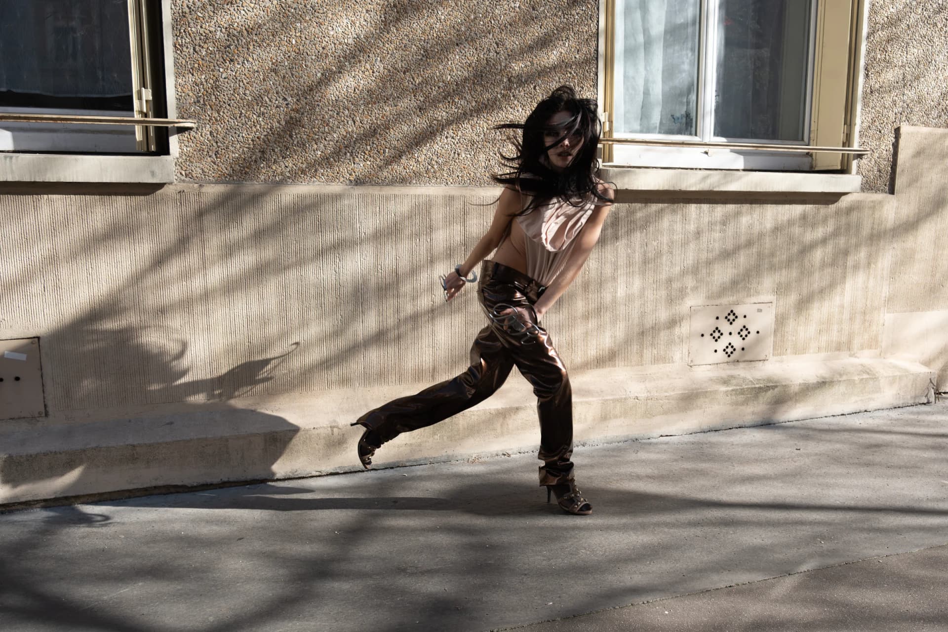model wearing iseder in motion against a city wall