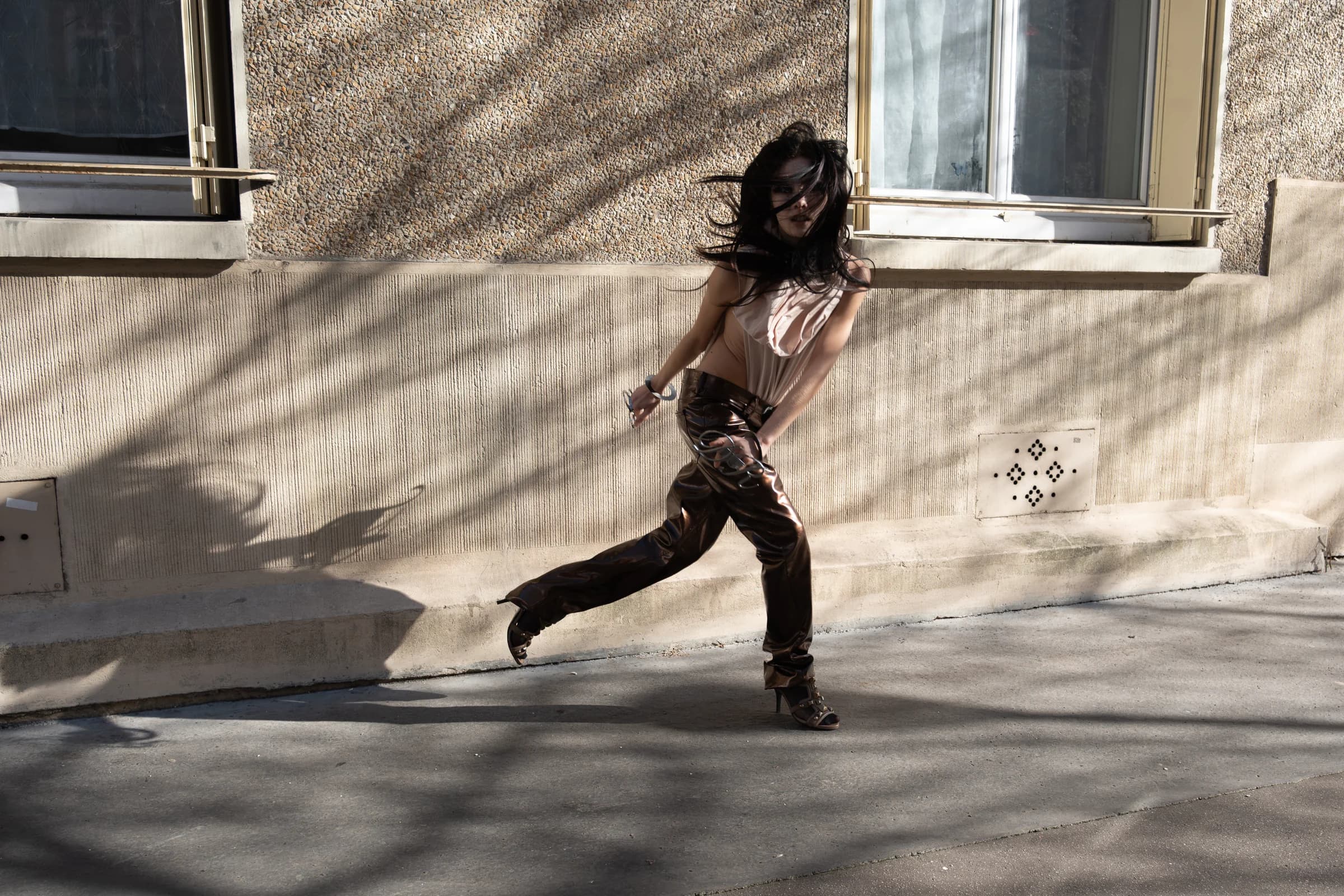 model wearing iseder in motion against a city wall